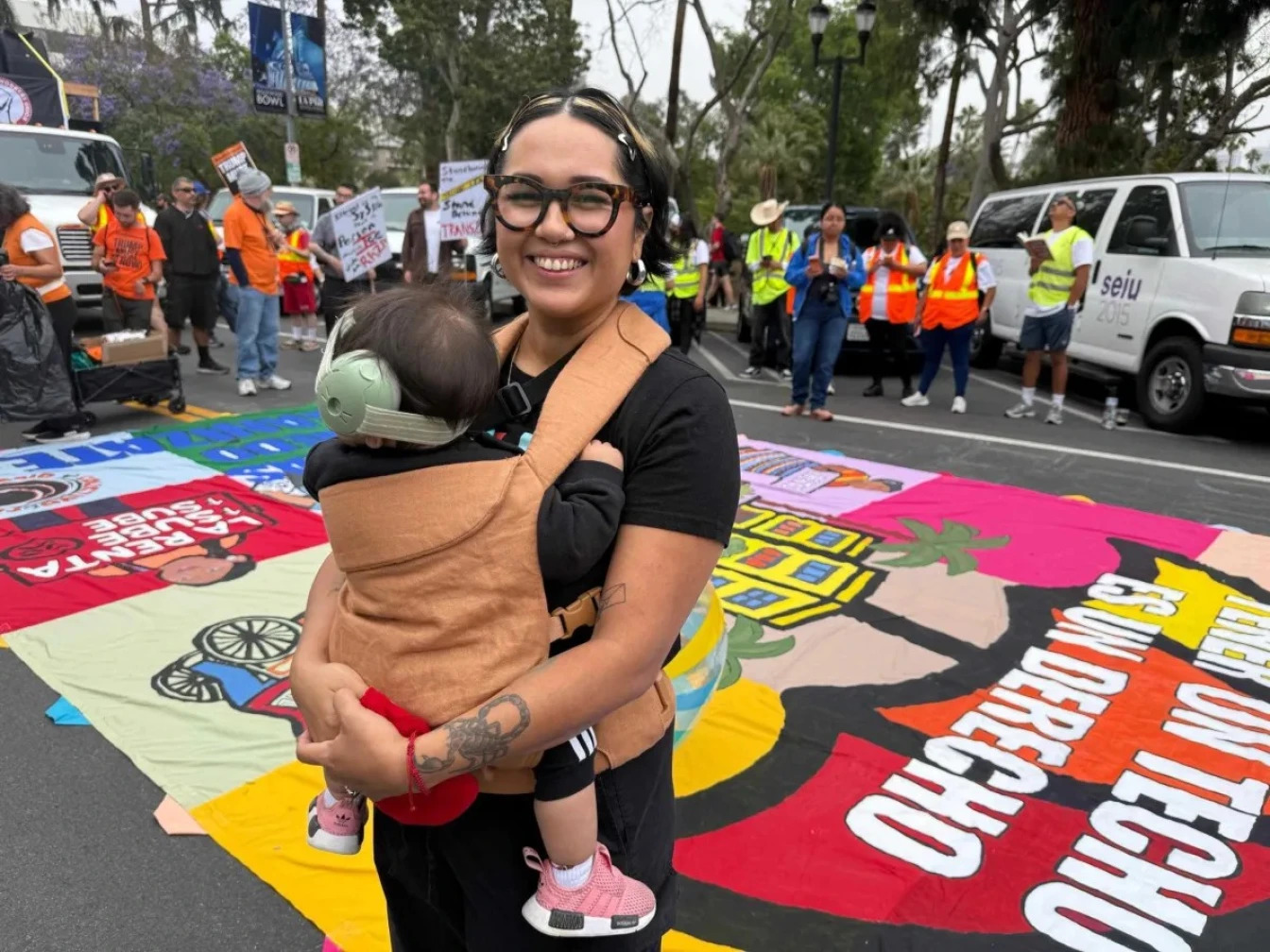 Woman holding her baby at the May Day LA event